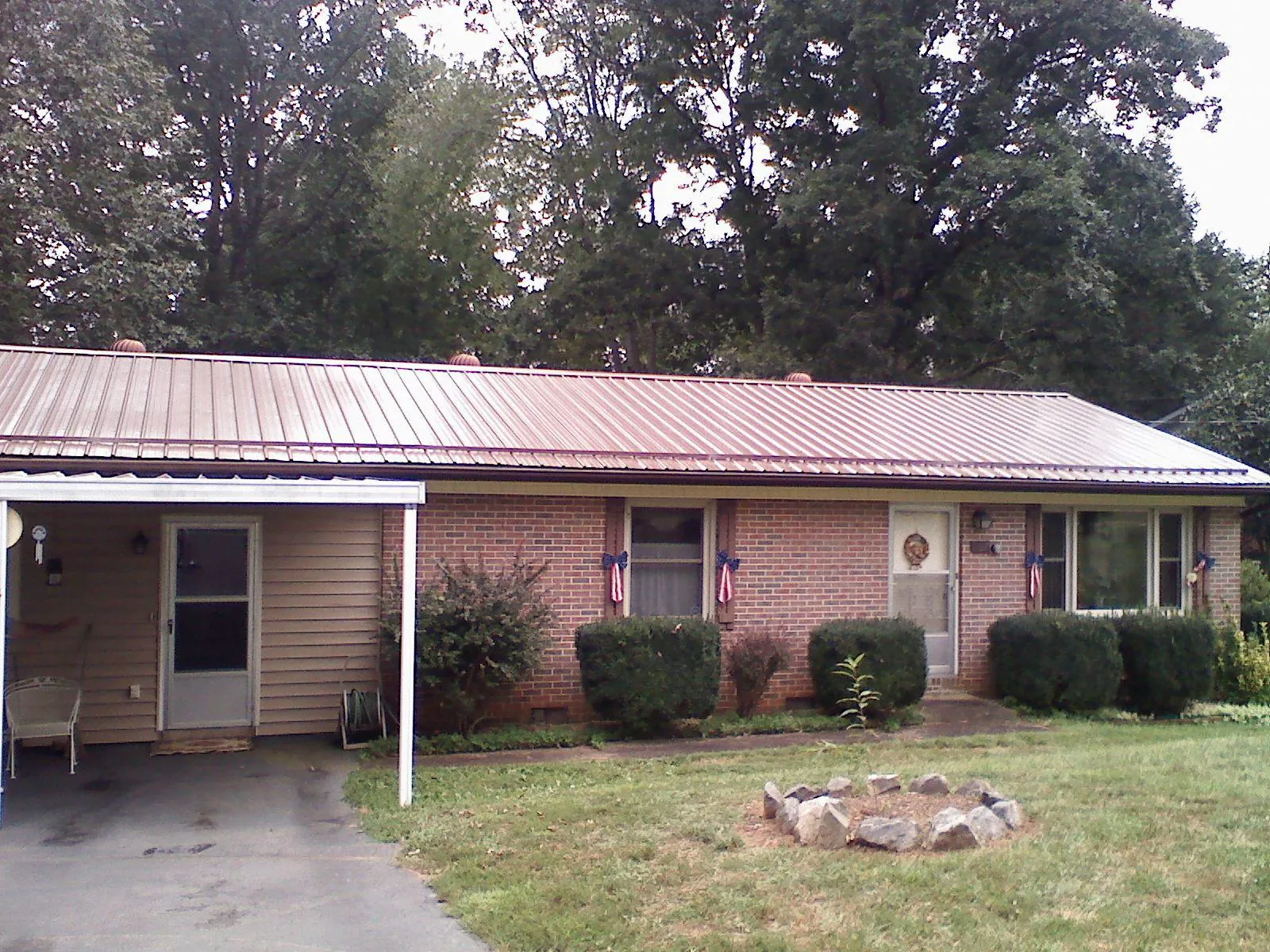 Bronze metal roof and carport on a brick ranch home — Roof Repair work by our crew in Barton
